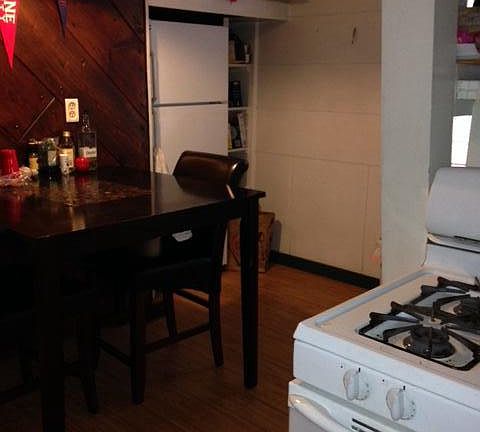 Up the Stairs to Kitchen showing Table, Refrigerator, Upper Cabinets & Stove