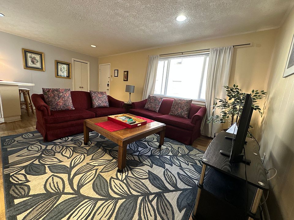 Inviting living room with two comfortable couches, a TV, dining area, and plenty of storage - welcoming you as soon as you step into the unit.
