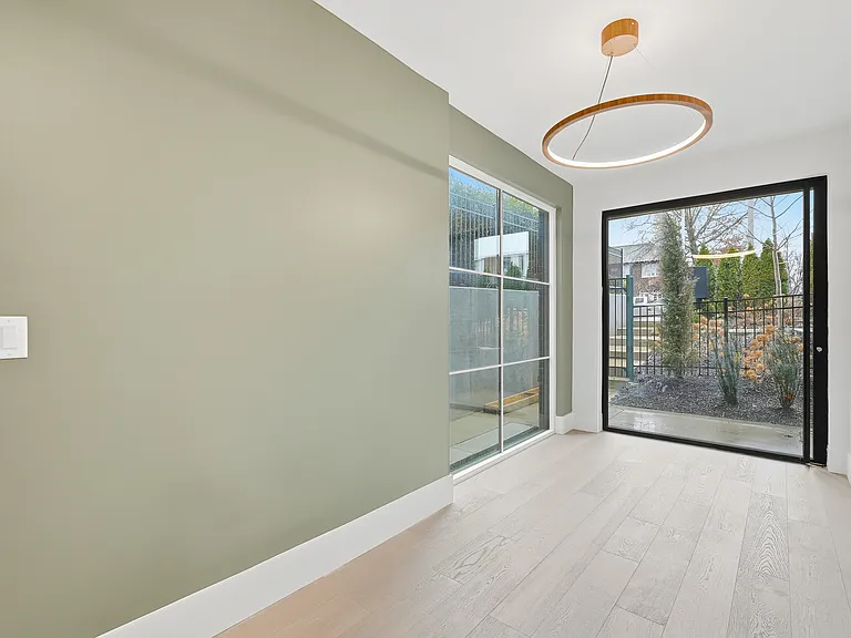 Bright entryway with modern lighting, accent wall, and access to a private outdoor space