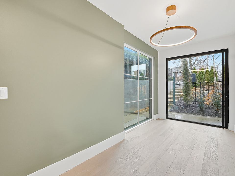 Bright entryway with modern lighting, accent wall, and access to a private outdoor space