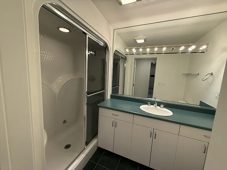 Fourth hallway bathroom is tastefully appointed with glass shower enclosures.