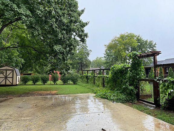 Fenced yard with raised garden bed and wildflower garden