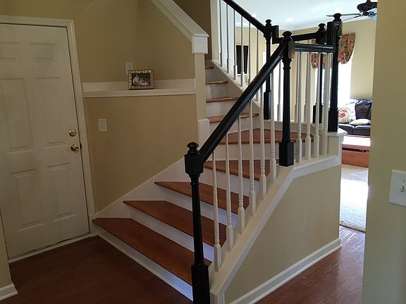 Staircase in foyer : Hardwood stair treads and oak railings painted ebony.