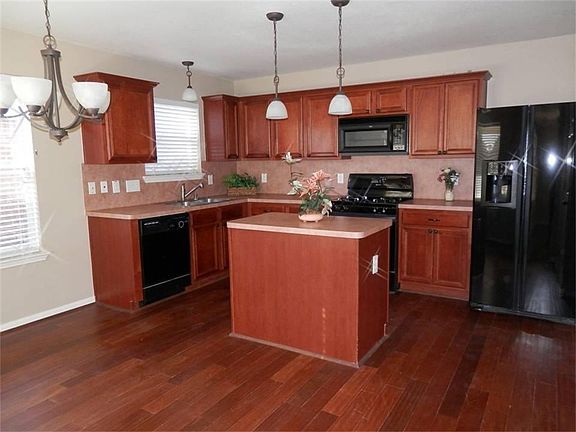 Island kitchen open to the breakfast room with a view to the private back yard.  Refrigerator and...