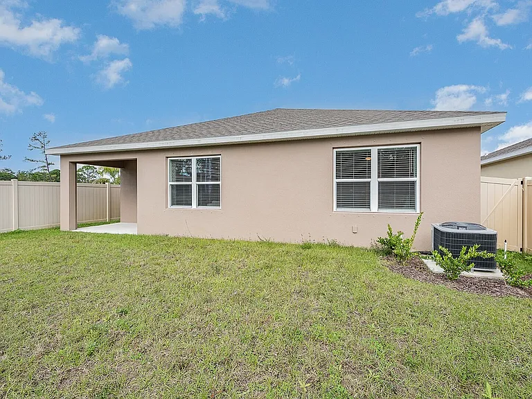 Charming single-story home with a large backyard, privacy fence, and modern exterior, perfect for outdoor enjoyment.