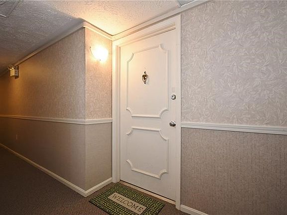 This is the front door to the unit. Hallway carpeting was updated recently. Nice neutral colors and well-lit space.
