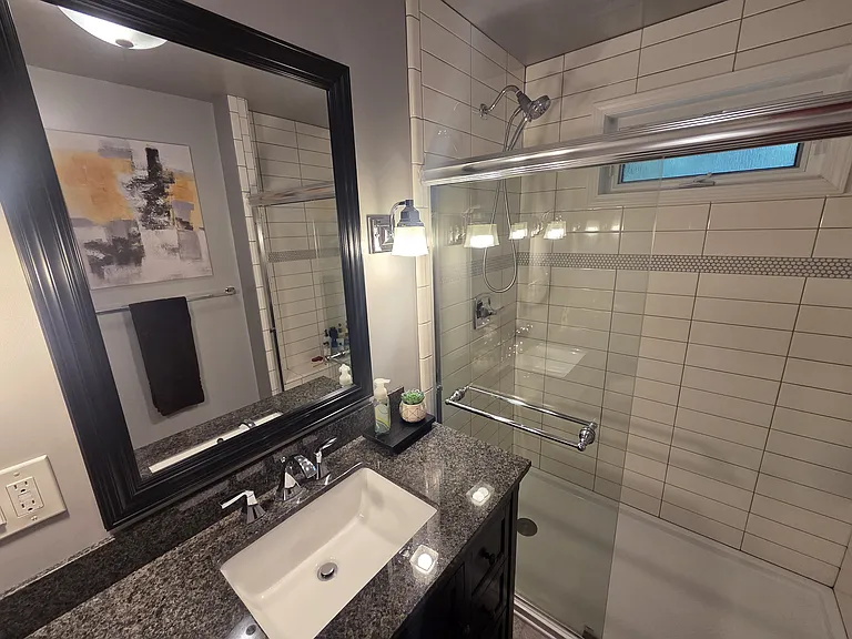 A modern, light-filled master ensuite behind elegant glass sliding doors, offering a private, serene escape