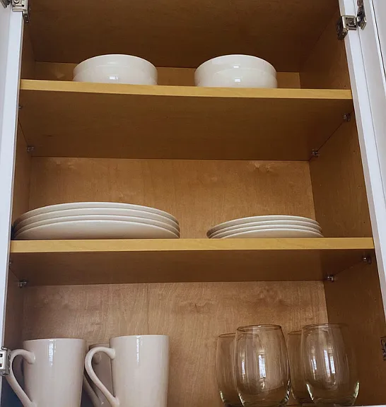Tableware set including flat and deep plates, glass cups, and mugs.