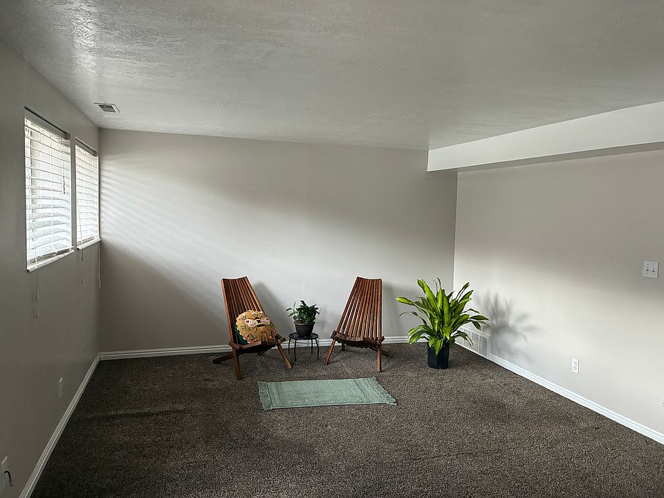 Large front room with lots of natural light from south facing windows, view of yard with beautiful scrub oak trees.