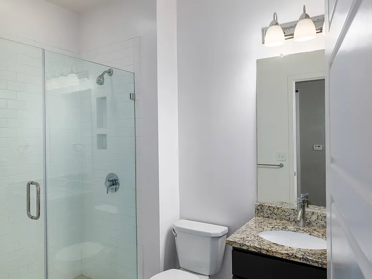 Bathroom with frameless shower at Leo