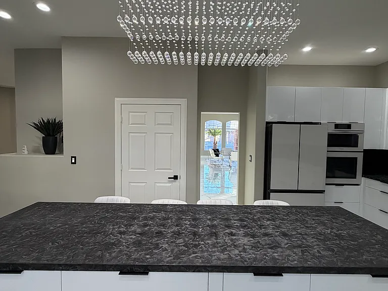 Elegant crystal chandelier anchoring the kitchen island.