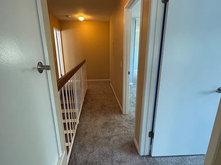 Upstairs hallway leading to the bedrooms with brand-new carpet throughout.