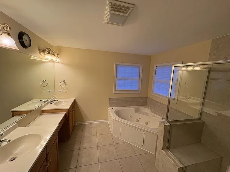 Double vanity primary bathroom with make up seat, soaking tub