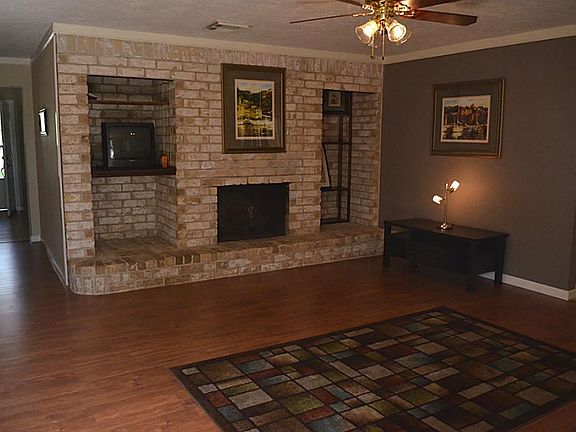  The family room has wood laminate flooring, crown molding, a lighted ceiling fan and a fantastic brick wall with wood burning fireplace and recessed niches... so unique and useful!
