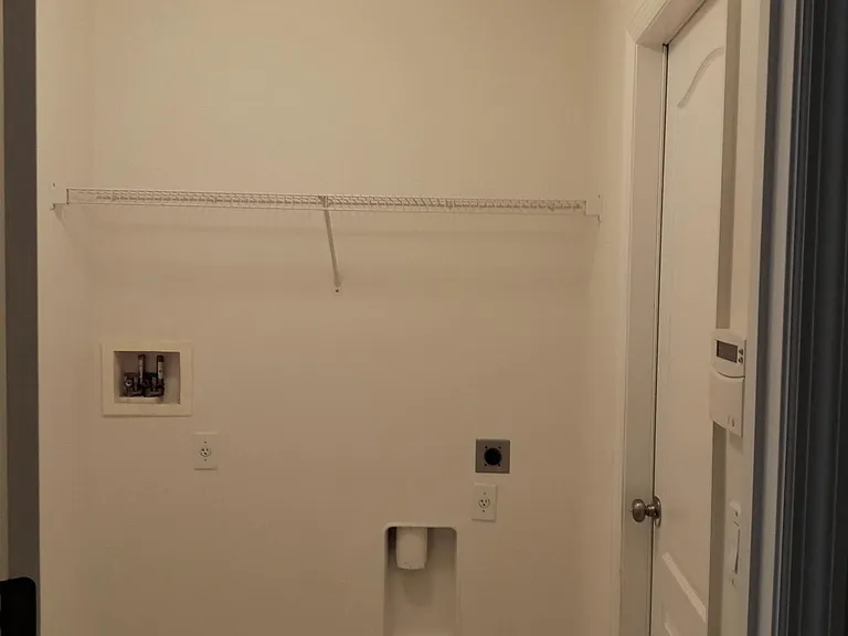 Laundry room hook-ups for your own washer and dryer. Garage doorway is to the right.