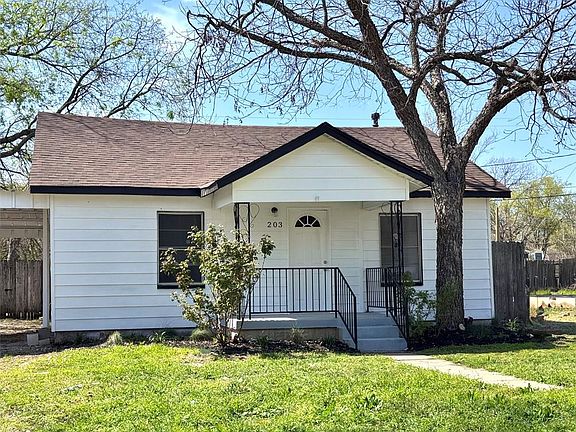 View of front of property featuring a front lawn, fence, and a shingled roof