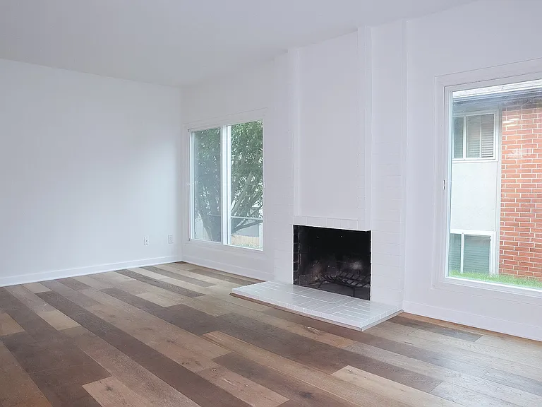 Living Room with hardwood floors and wood-burning fireplace.
