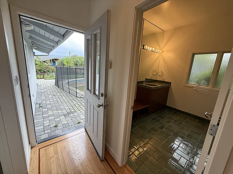 The pool bathroom are tastefully appointed with glass shower enclosures and organized storage.