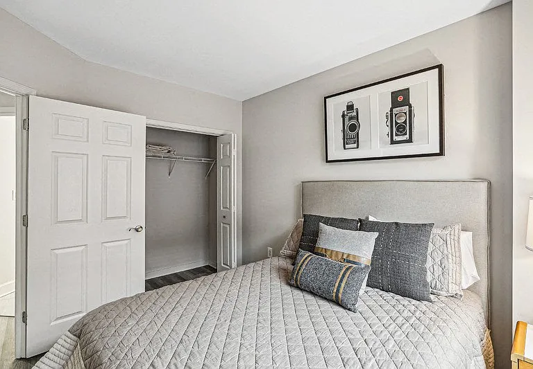 Apartment Bedroom Featuring Double Door Closet and Upholstered Bed