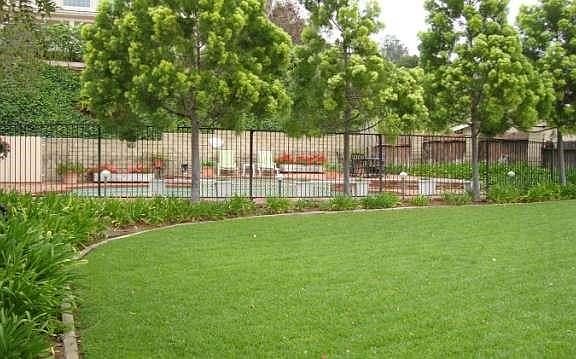 Large lawn with easy maintenance landscaping in front of your fenced pool entertaintment area.