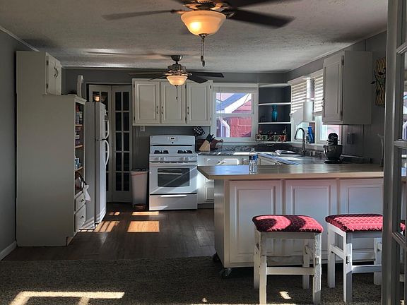 French doors leading into a dining room kitchen open concept lots of cabinet space and a floating island. New garbage disposal dishwasher sink and nice faucet, gas stove and refrigerator. This picture is from the living room looking into the kitchen when