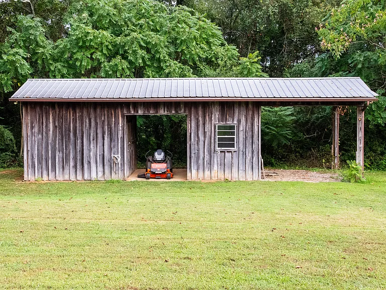 Barn in the back yard with 2 large storage areas and a car port