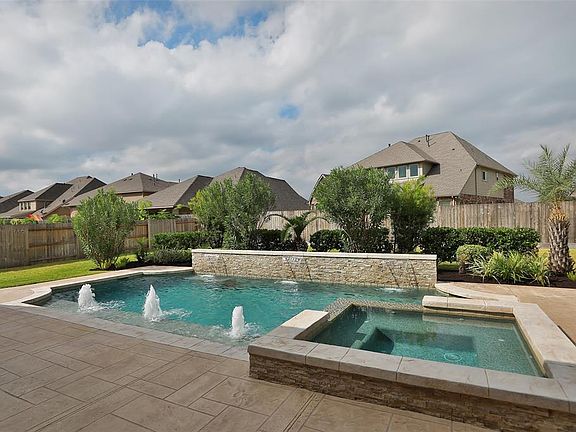 Stunning pool and spa with multiple water features and covered patio are a GREAT way to keep cool on the hot summer days.