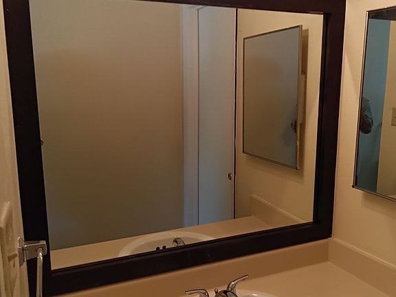 Dressing area and vanity with large framed mirror.