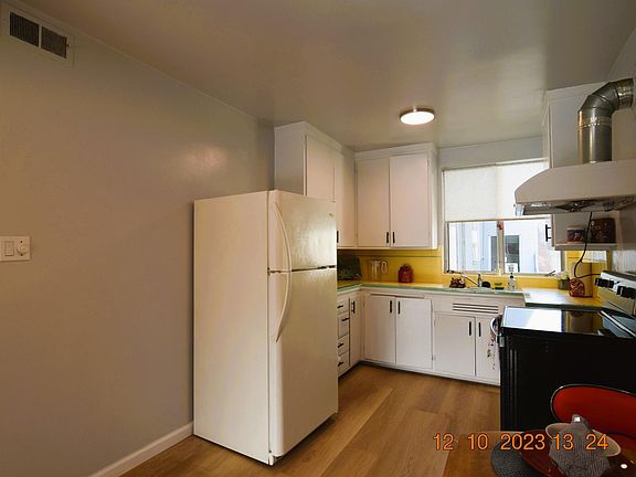 Large kitchen with new laminate floors, lots of cupboards and dining area with a light dimmer.