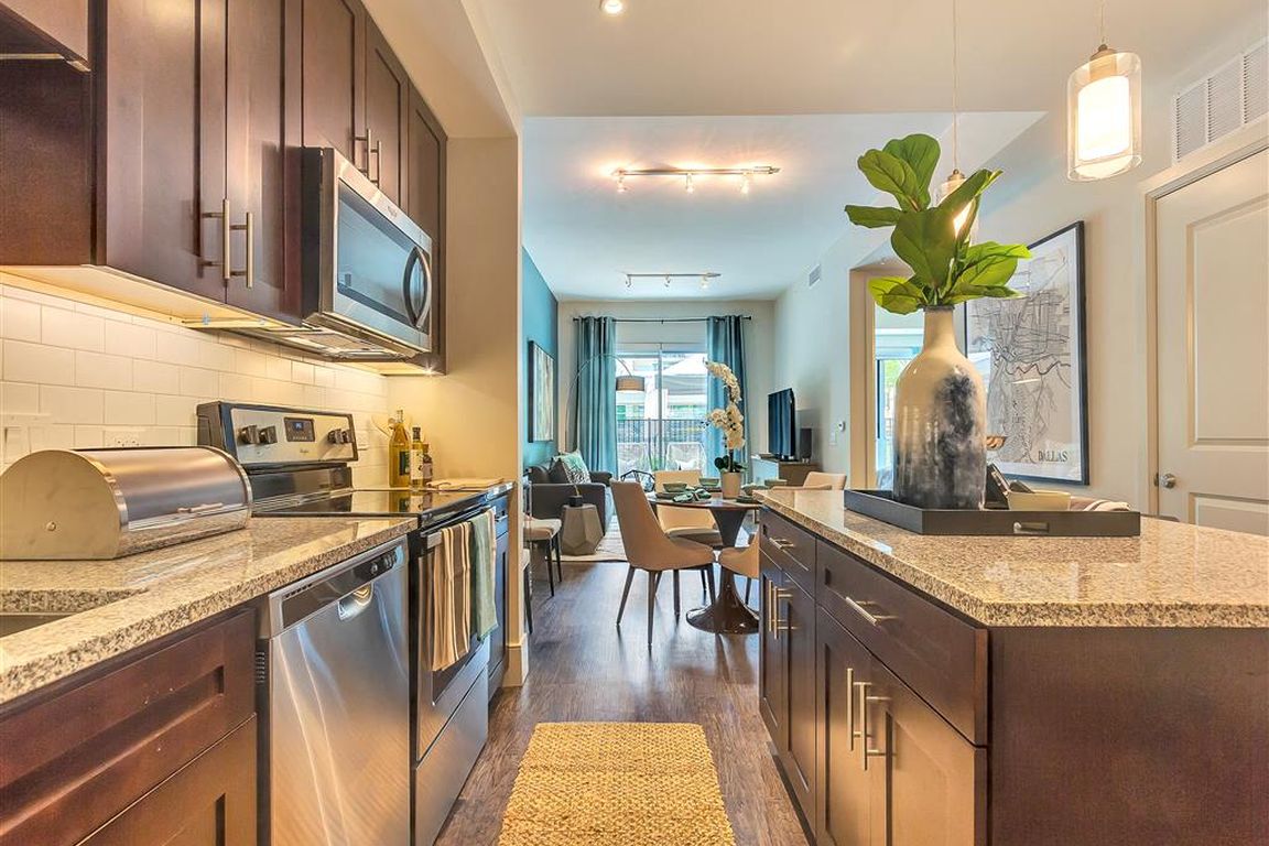 Large kitchen island with hardwood flooring and dark cabinets