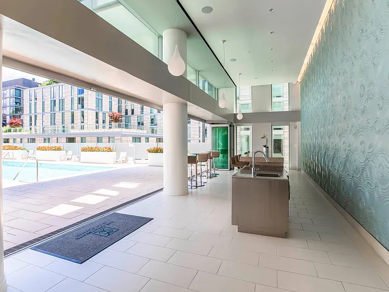 Transition seamlessly from stylish interiors to the sun-drenched pool deck in this upscale lounge and bar area, perfect for hosting or relaxing.