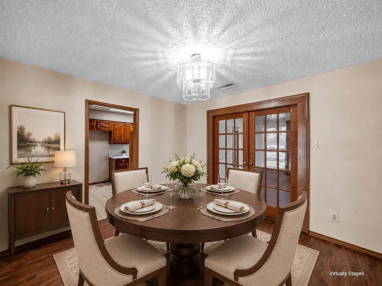 Formal dining room with hardwood-look finish flooring complementing light-toned walls