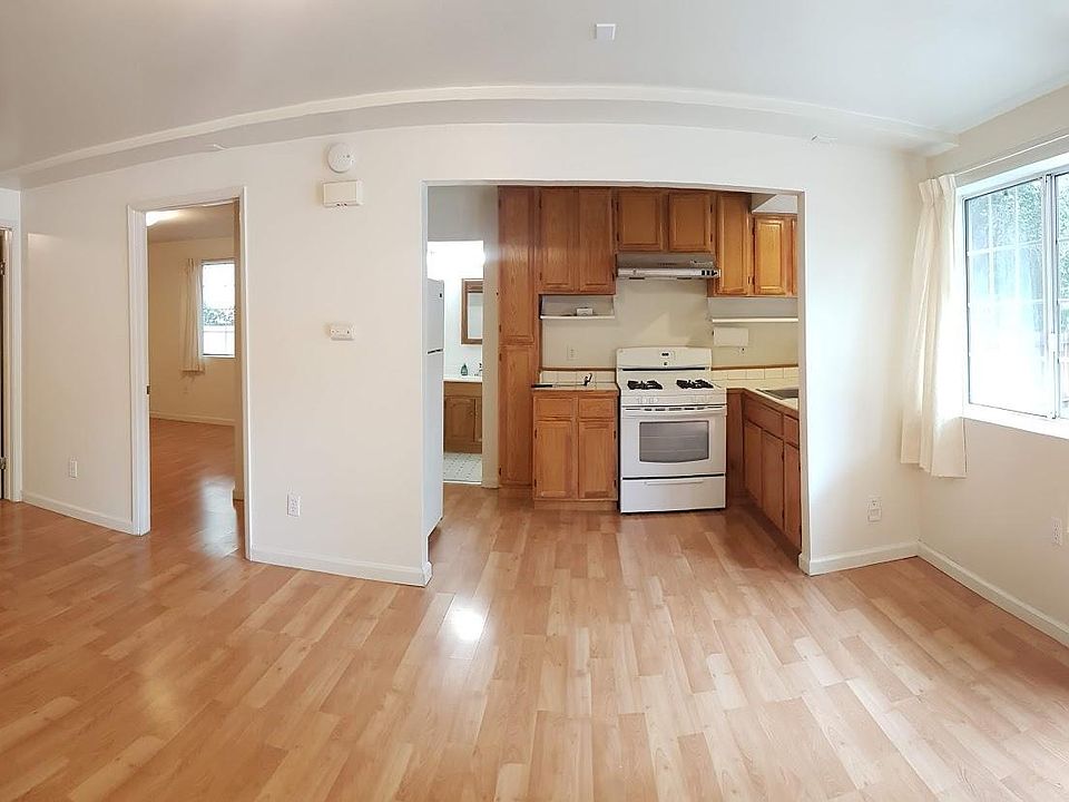 Living room and kitchen area. Entrance to bedroom #1 on far left, entrance to bedroom #2 in the middle.