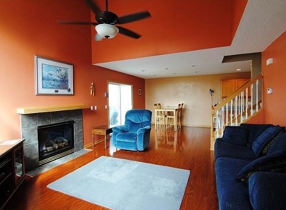 2 story great room with ceiling fan, updated flooring, and a tiled gas fireplace.