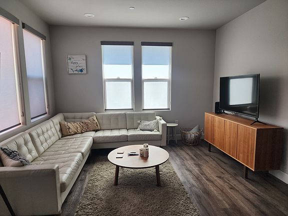 Faux leather couch in the dining room with a large screen TV.
