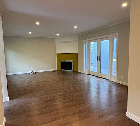 Living room with gas fire place and glass door opening to middle patio