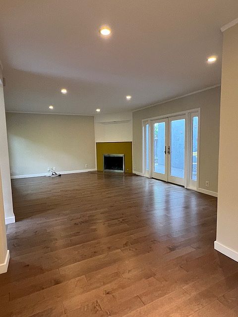 Living room with gas fire place and glass door opening to middle patio