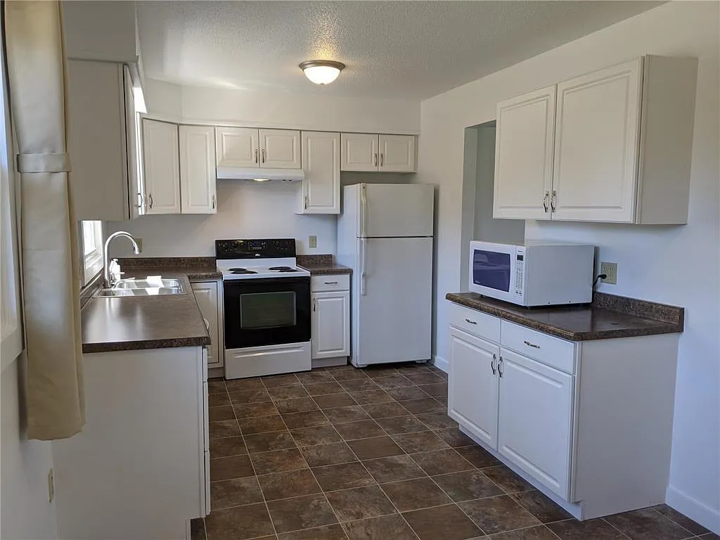 Large kitchen with fridge, range, dishwasher and microwave. - 12905 Pilgrim Ln N #12905