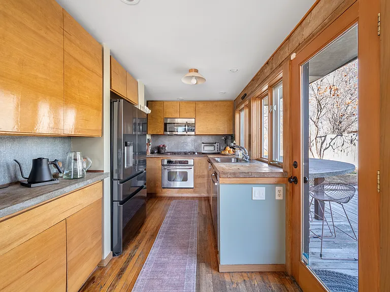 Kitchen with wooden patio out glass door.
