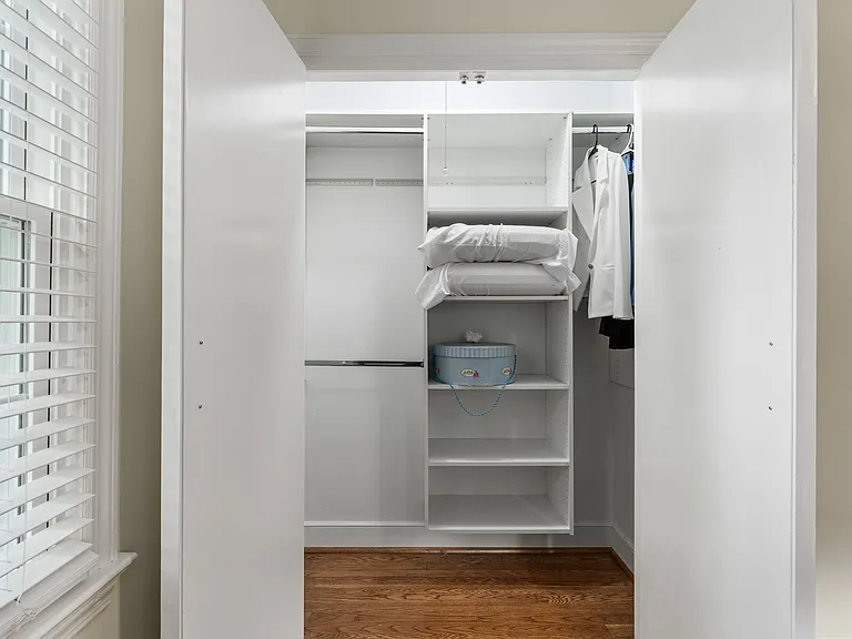 Professional closet organizer in primary bedroom.