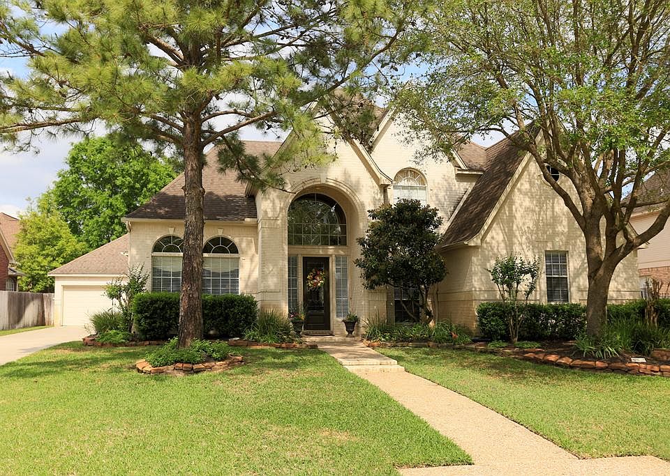 Gorgeous landscaping amplifies the curb appeal on this beautiful home in Spring Creek Oaks.