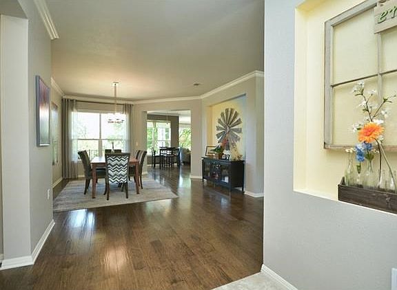 This view looks across recent wood flooring into the dining area and beyond from the Foyer.  A lighted art niche is the perfect spot for your favorite piece of art.