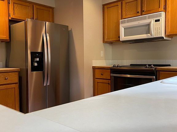 New Whirlpool refrigerator and single oven electric range and stovetop.