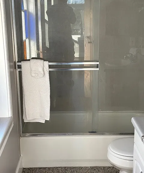 Bathroom has tub with shower.