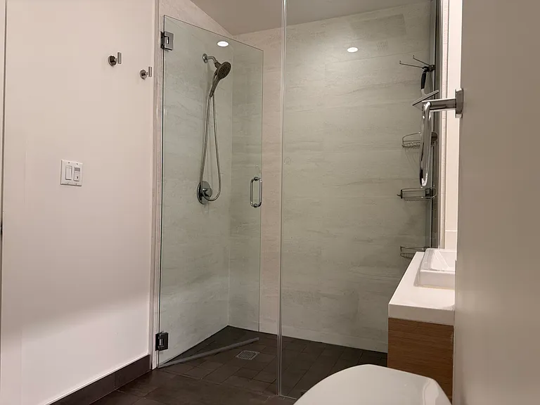 Kohler shower with magnetic removable handle.
Sturdy glass doors and convenient hooks for towels.