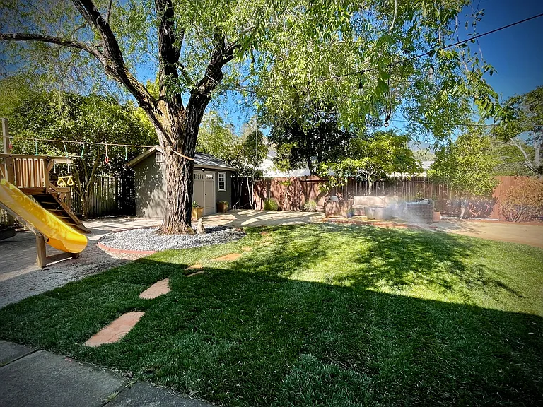 Backyard...wonderful lawn, play structure, outdoor deck, insulated office shed!
