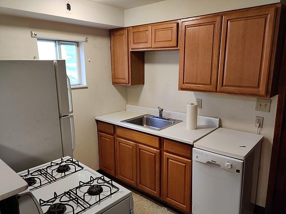 Kitchen with newer dishwasher and new cabinets.