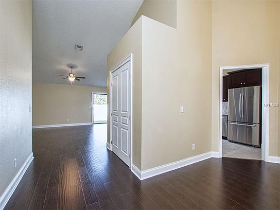 Entry door view from foyer down wide hall to back yard slider.  Off to the right is the dining room with entrance to kitchen