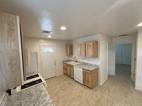 The home features new ceramic tile floor, new paint and texture, new air conditioning, and more. The kitchen door leads to a private covered patio with washer and dryer hook-ups.