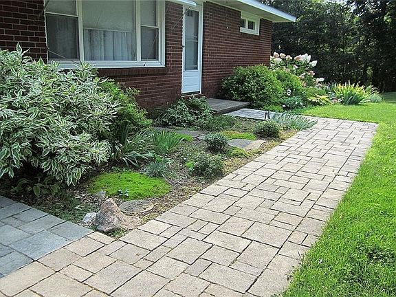 The newer and tastefully done Paver Brick front walkway encompasses the low-maintenance perennial garden on three sides.